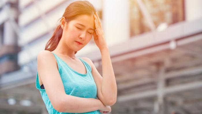 Một vận động viên chạy bộ đang cảm thấy chóng mặt và phải dừng lại nghỉ, hình ảnh minh họa nguyên nhân tụt đường huyết khi chạy.