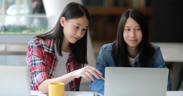 Một nhóm sinh viên đang khởi động trên sân thể thao của trường đại học, minh họa cho việc học thể dục