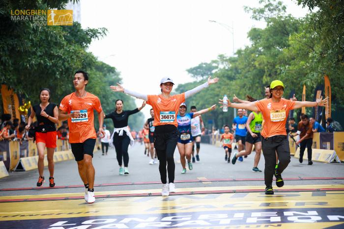 Lịch chạy bộ 1 tuần được đánh dấu trên cuốn lịch để bàn, bên cạnh là một đôi giày chạy và chai nước, thể hiện sự khoa học và kế hoạch.