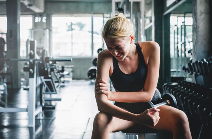 Một người đang thực hiện động tác giãn cơ động trong phòng gym, chuẩn bị cho buổi tập luyện theo hướng dẫn bằng tiếng Anh